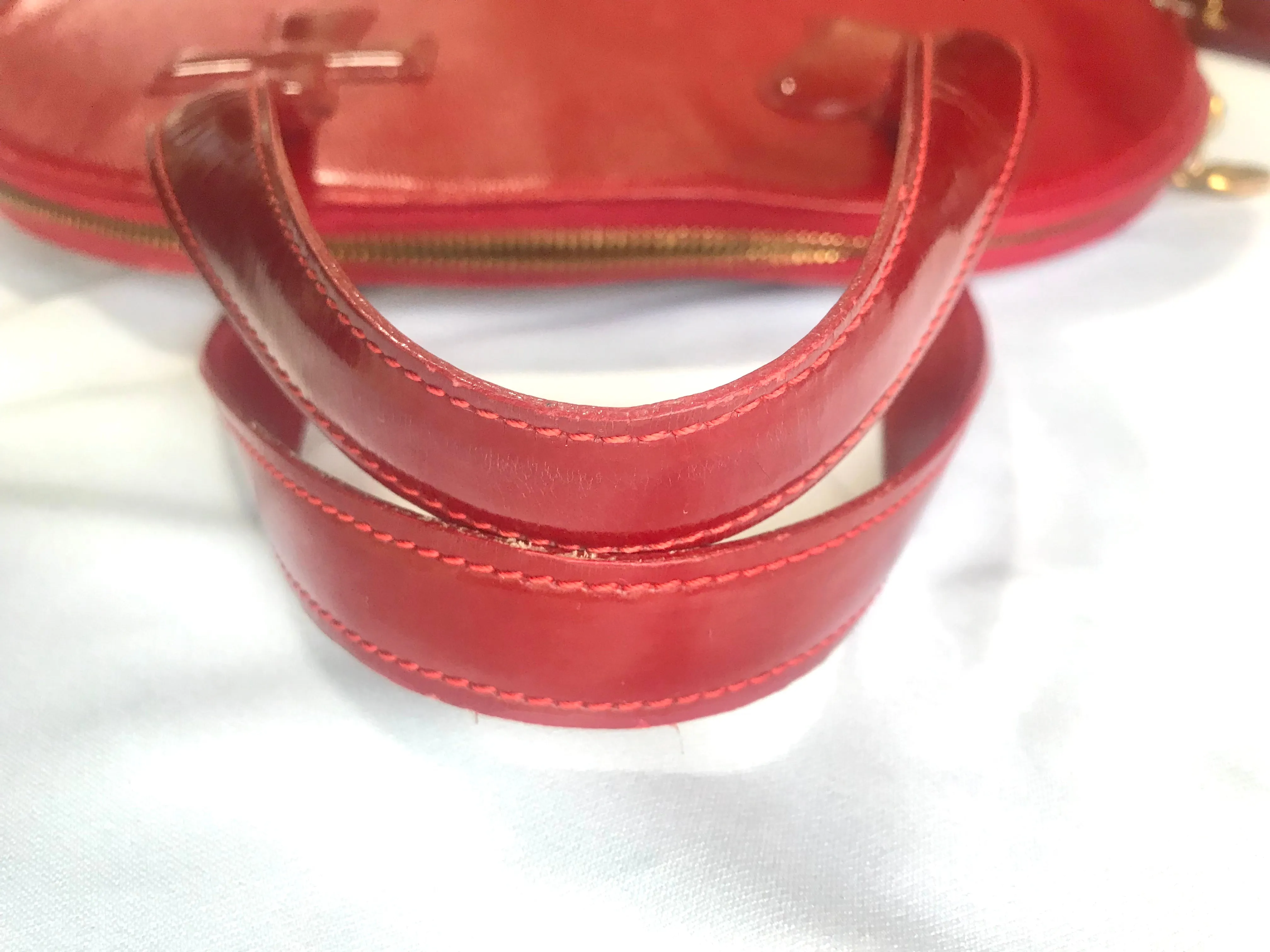 Vintage Christian Lacroix red patent enamel and leather bolide bag with golden logo zipper charm. Comes with shoulder strap. 0403172